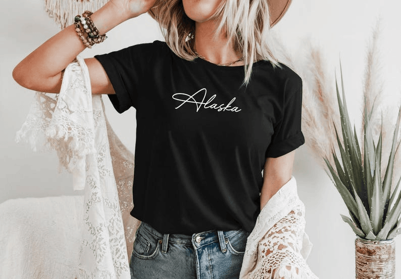 Black T-shirt with Alaska written in white cursive across the chest